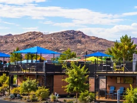 Cabins with rooftop decks and shade canopies against the red hills