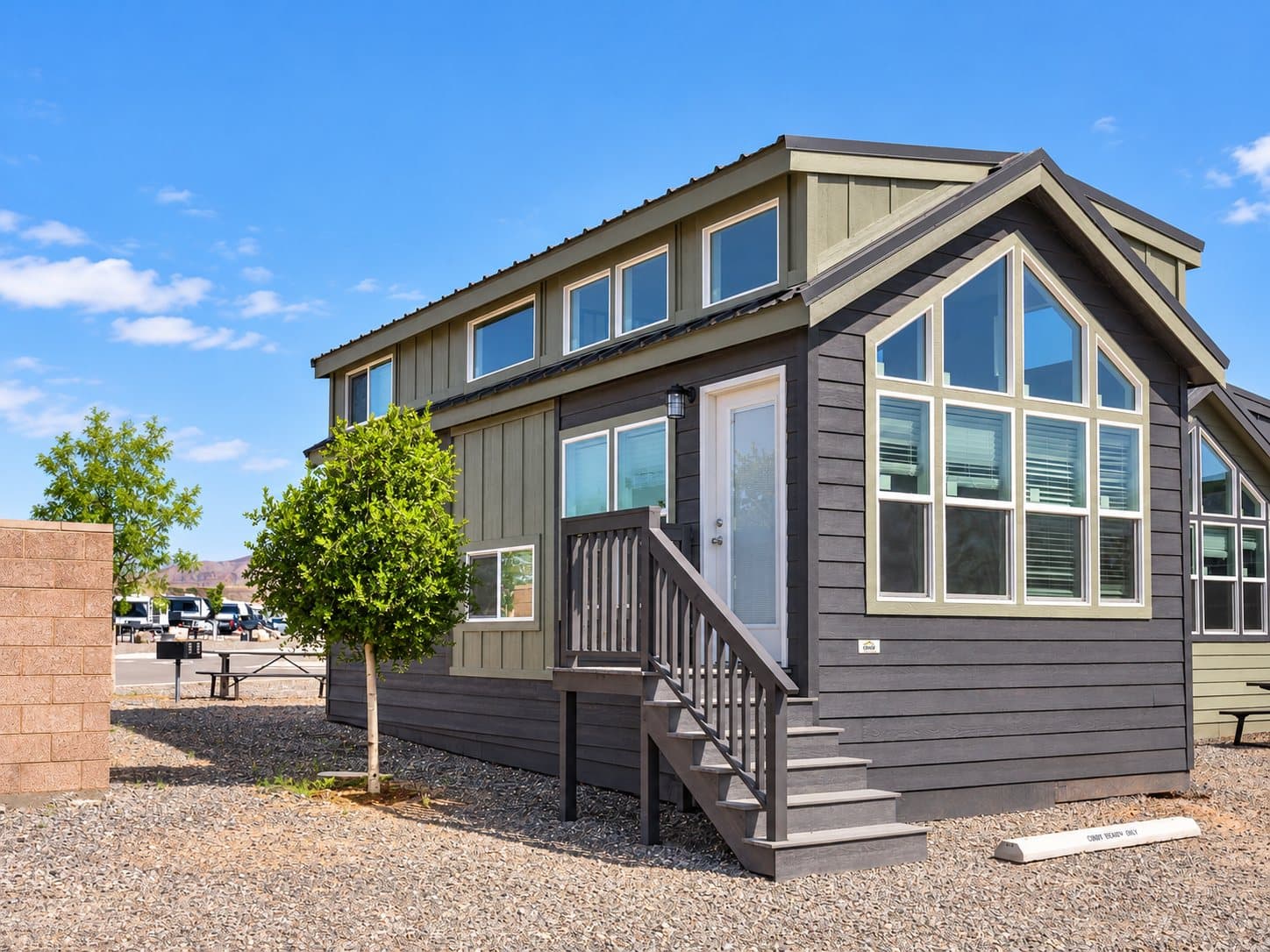 A two-bedroom cabin with a covered porch and red cliffs behind