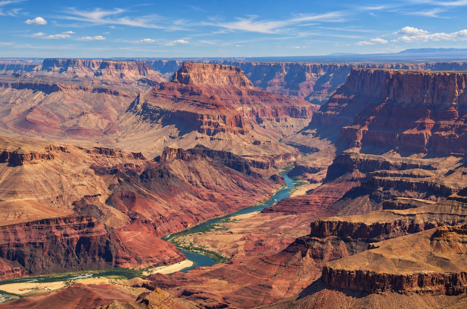 The Colorado River winds between layered cliffs and mesas in the Grand Canyon.